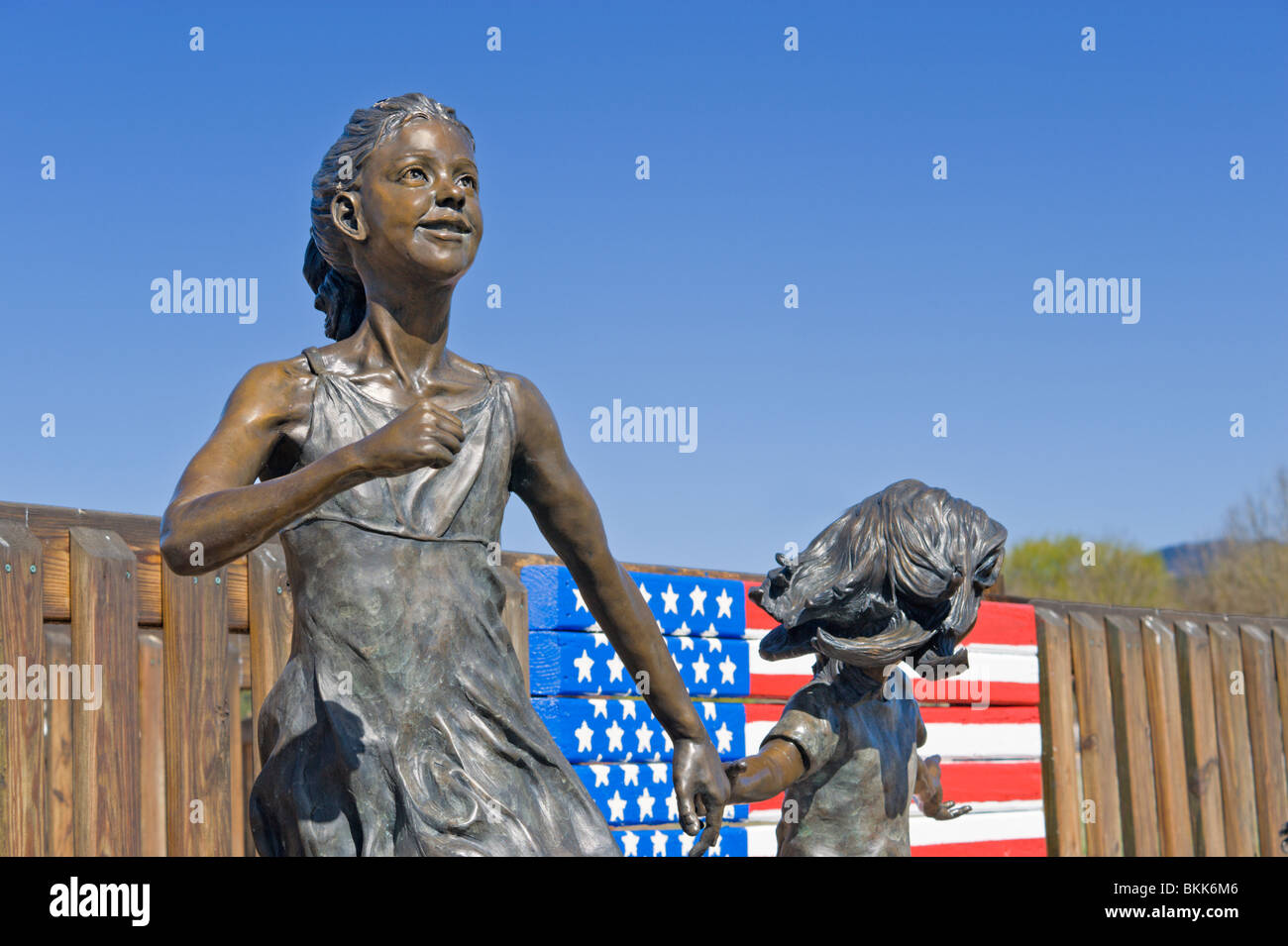 Eine Bronzeskulptur von spielenden Kindern ziert die "Konnection Spielplatz", in der Ski Resort Stadt Ruidoso, New Mexico. Stockfoto