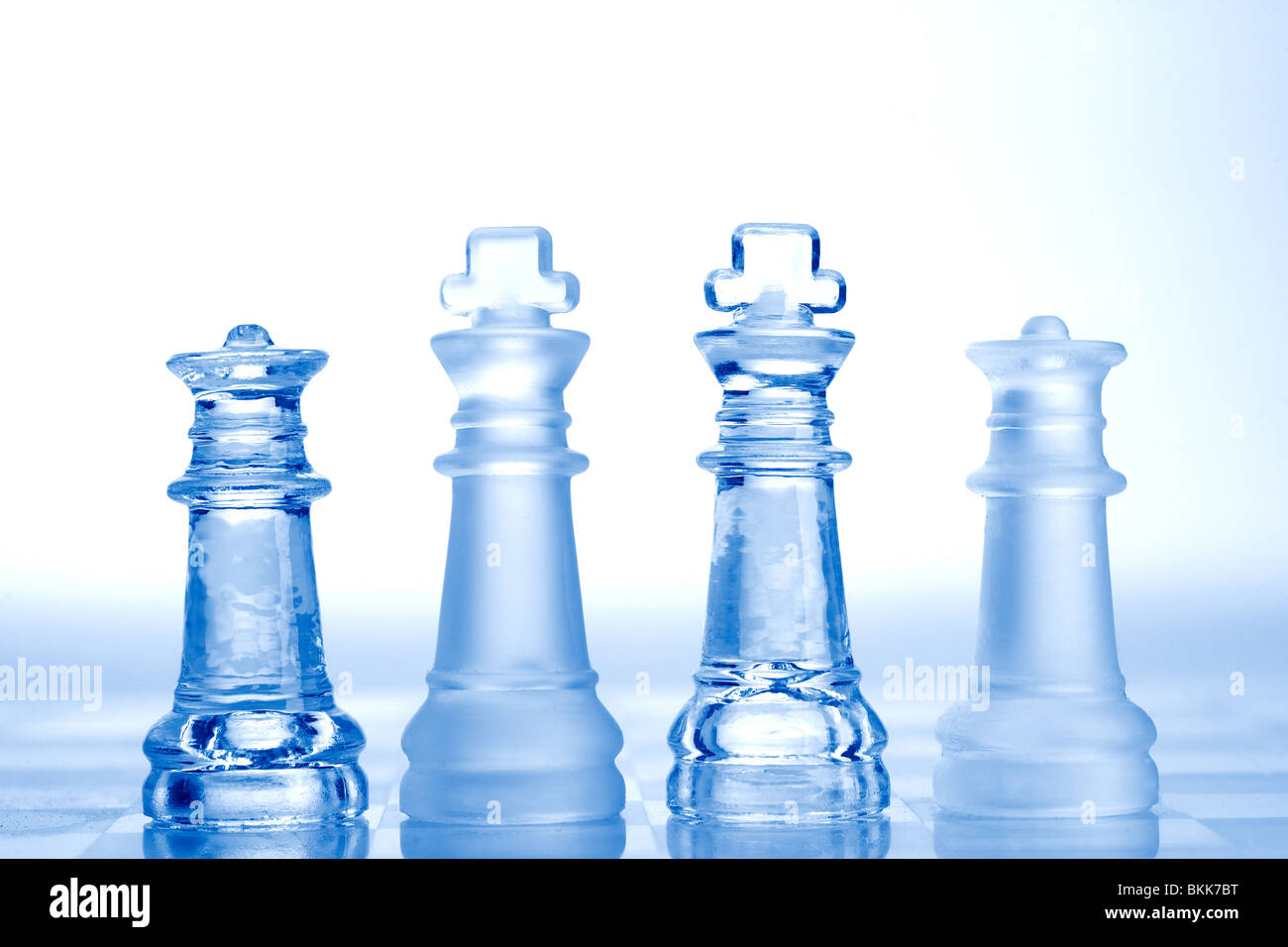Glas-Schachfiguren mit blauem Licht Stockfoto
