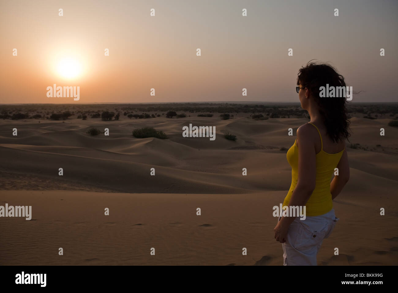 Frau auf der Suche At Sunset Khuri Dünen in Thar-Wüste in der Nähe von Jaisalmer im Staat Rajasthan in Indien Stockfoto