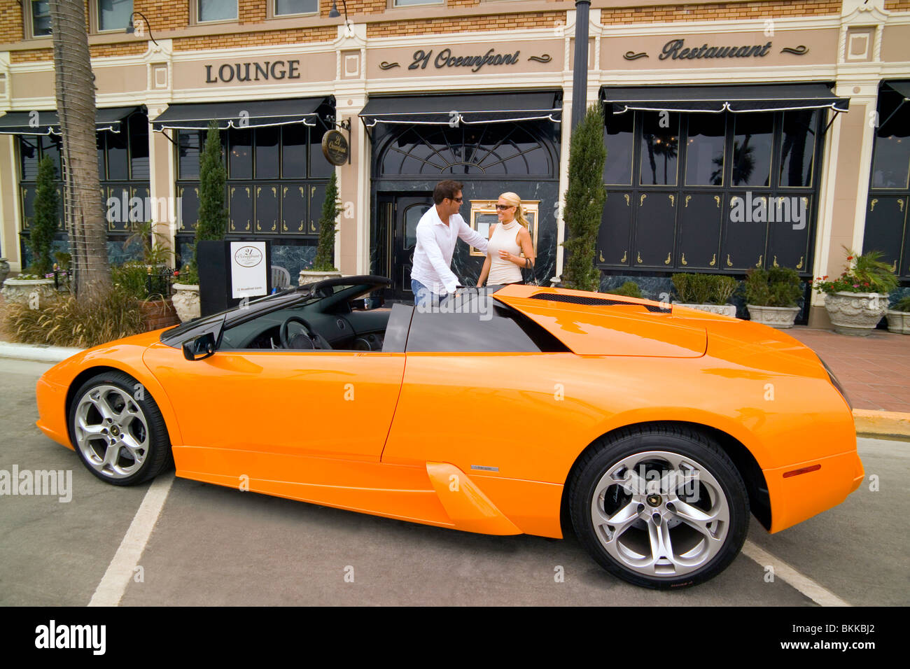 Ein paar kommt in ihren Sportwagen auf der modischen 21 Strandrestaurant, ein langjähriger Favorit für feines Essen in Newport Beach, Kalifornien. Stockfoto