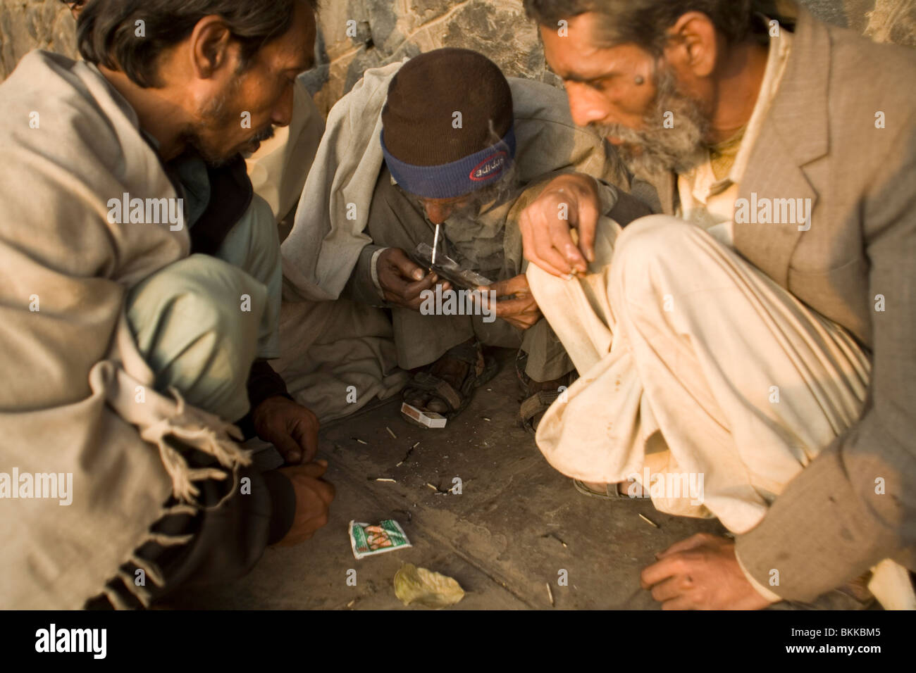 Eine Gruppe von Obdachlose Männer rauchen billig Heroin in einem Gebiet voller Not leidenden und Armen nahe der Jama Masjid. Delhi, Indien Stockfoto