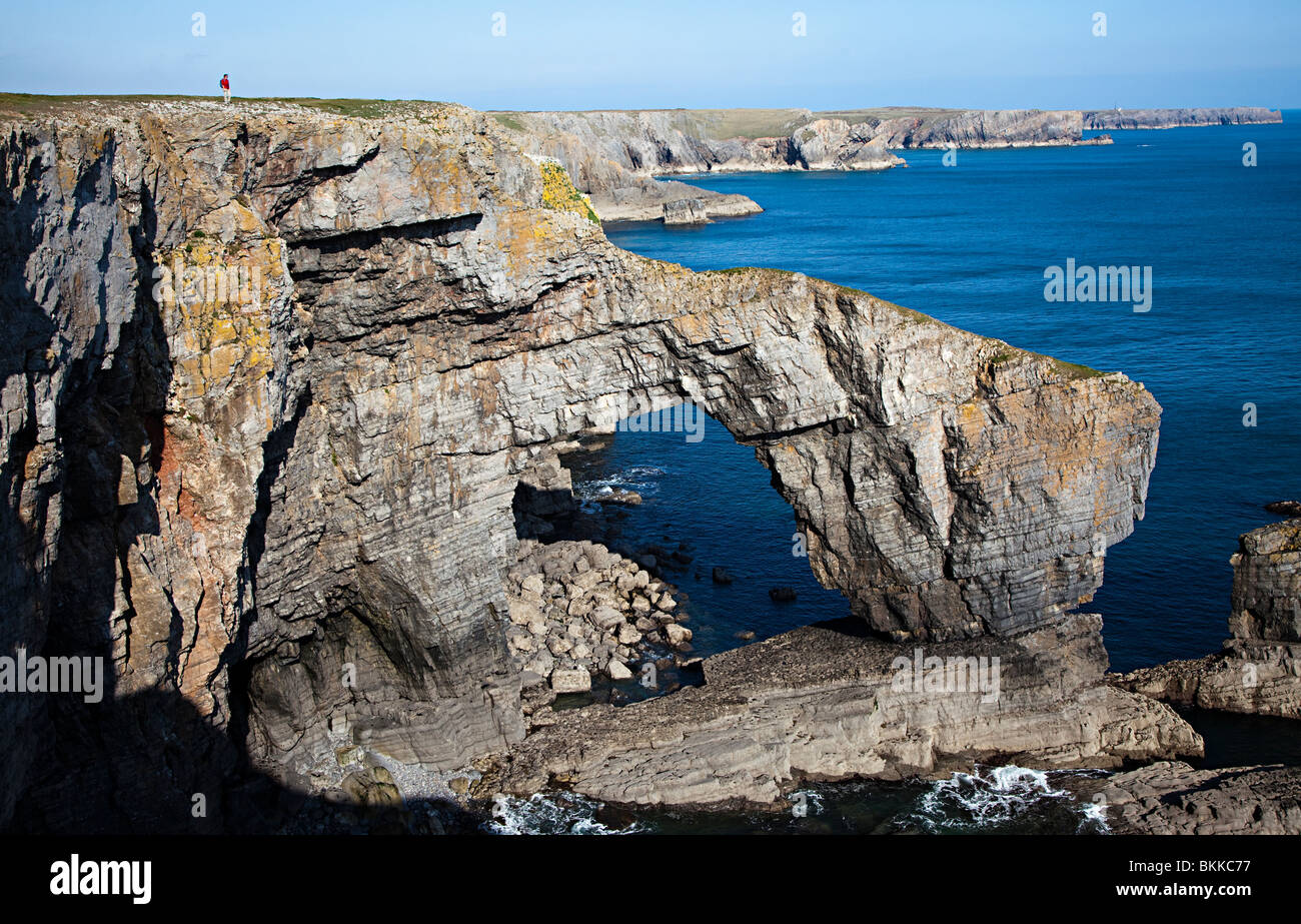 Walker auf Klippe an der grünen Brücke Pembrokeshire Wales UK Stockfoto