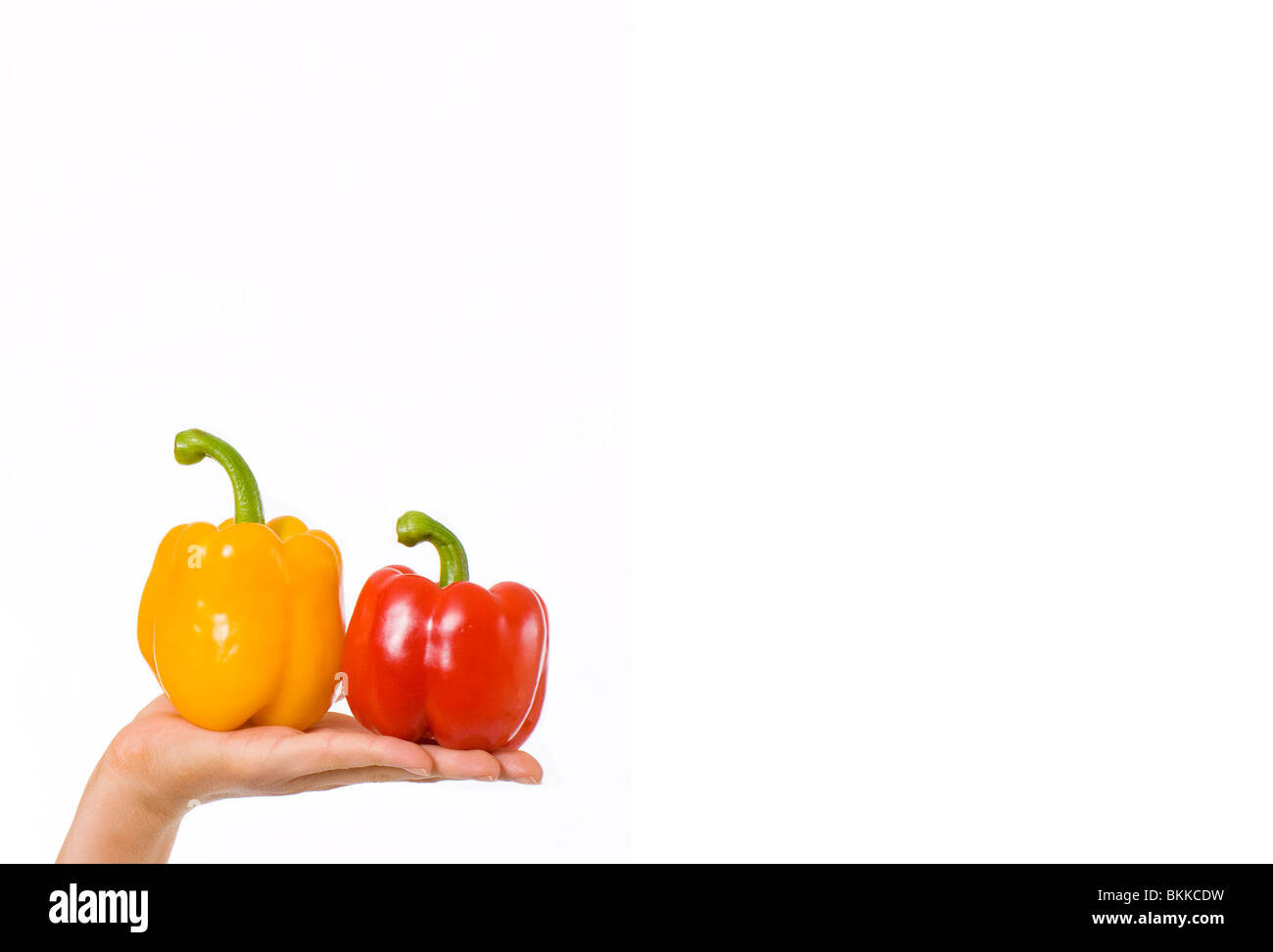 Junge Frau mit roten und gelben Paprika Stockfoto