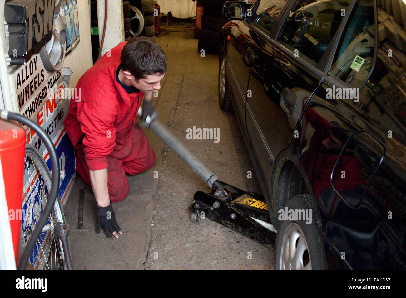 Mechaniker mit Rangierwagenheber, Auto in einer Garage zu heben Stockfoto