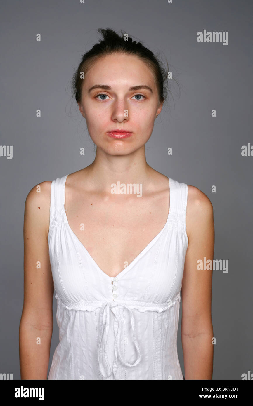 Dünne weiße Frau mit weißem Kleid im Studio. Stockfoto