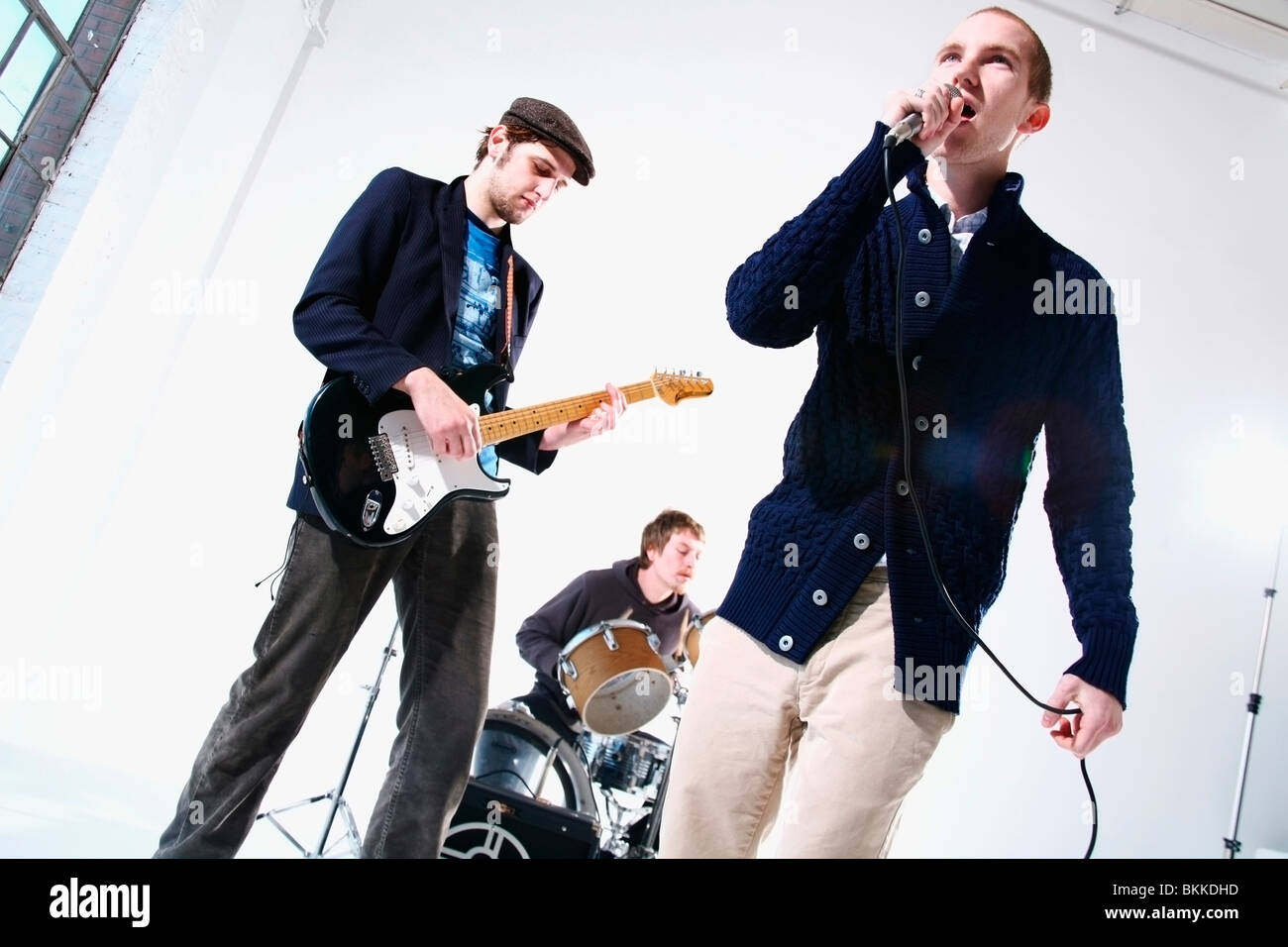 Eine Band mit Sänger, Schlagzeuger und e-Gitarrenspieler Stockfoto