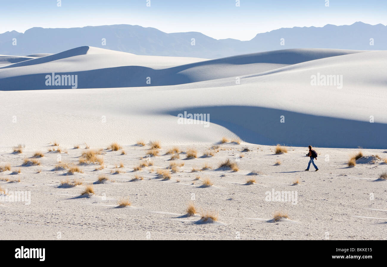 Eine Person zu Fuß unter großen weißen Sanddünen in White Sands National Monument, New Mexico. Stockfoto