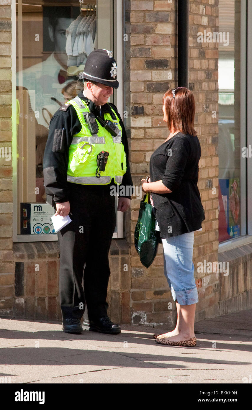 Polizist hat freundliches Gespräch mit einer Frau auf der Straße Stockfoto