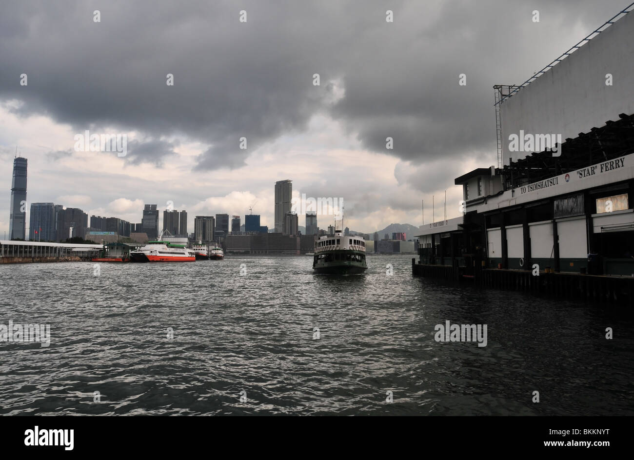 Star Ferry, gegen den dunklen Himmel von Kowloon Kulisse, nähert sich der Wan Chai Ferry Terminal, Victoria Harbour Hong Kong Stockfoto