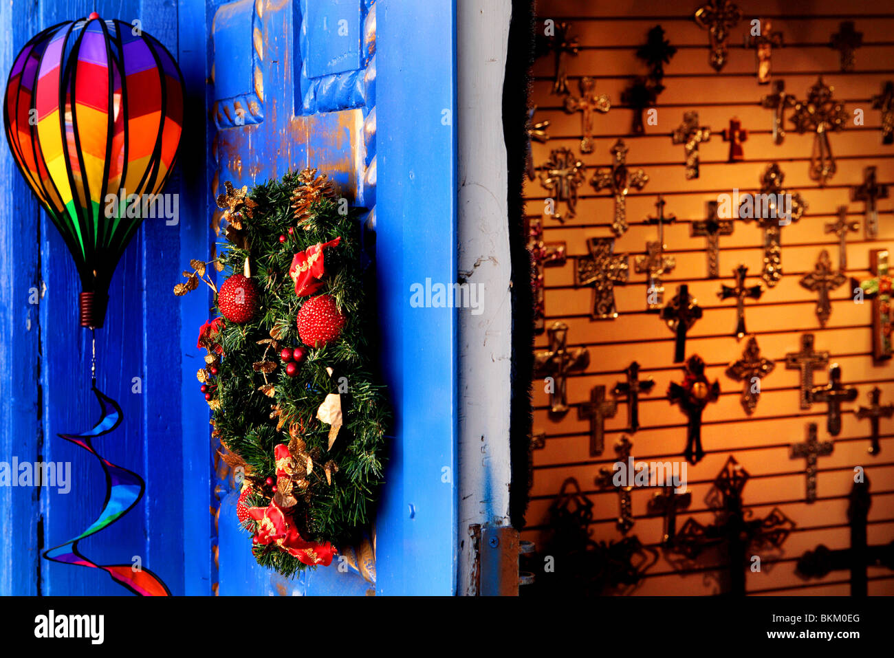 BLAU UND GOLD BEMALTE HOLZTÜR, BUNTEN BALLON, CHRISTBAUMSCHMUCK UND KRUZIFIXE ZU VERKAUFEN IN ALBUQUERQUE, NEW MEXICO, USA Stockfoto