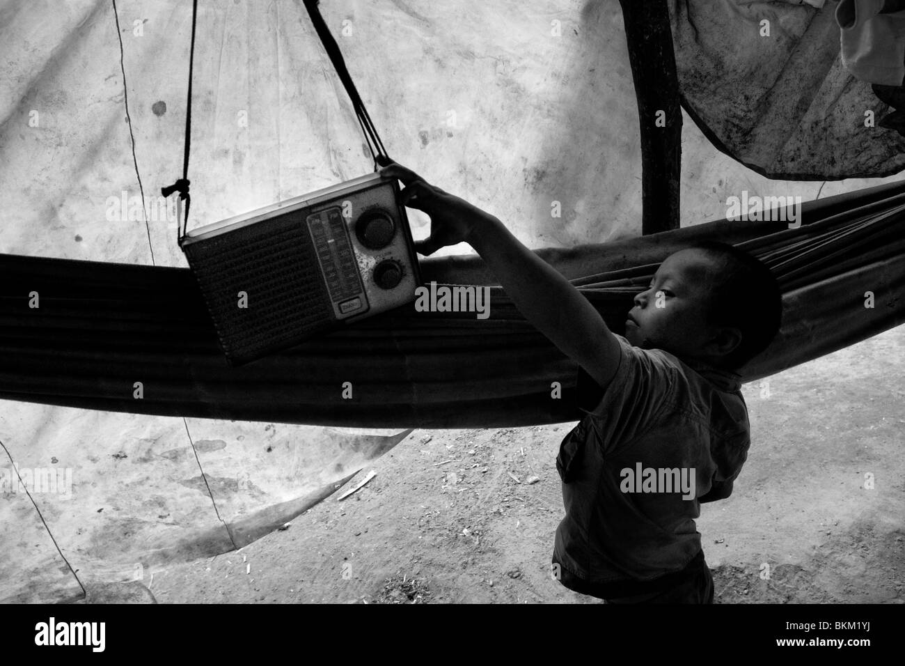 Die Nukak junge schaltet das Radio, die ihnen von den Missionaren in einem flüchtling Feldlager in der Nähe von San José del Guaviare, Kolumbien. Stockfoto