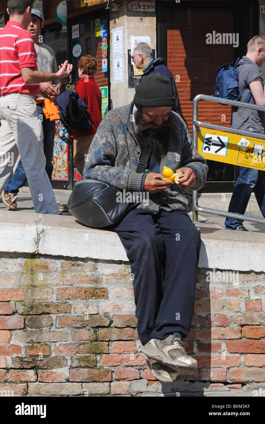 Obdachloser Essen eine Orange, Venedig, Italien Stockfoto
