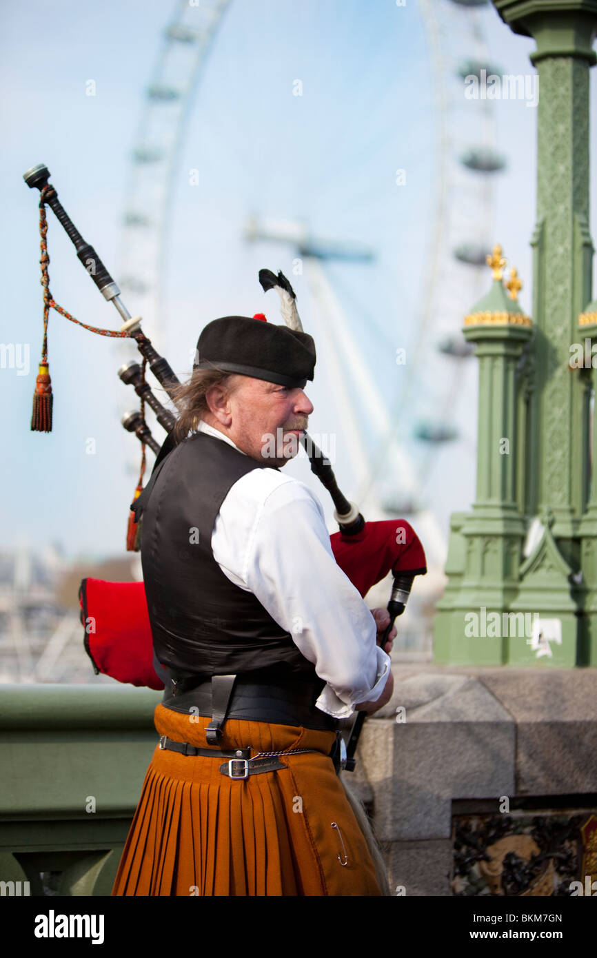 Halblängen Porträt von schottischen Tasche Piper spielt mit London Eye in den Hintergrund, England, UK Stockfoto