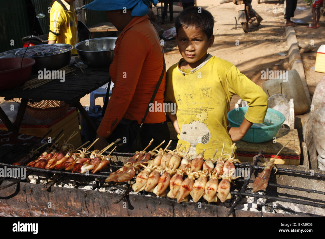 Ein Junge verkauft gegrillten Tintenfisch in Kep Krabben Markt in Kambodscha. Stockfoto