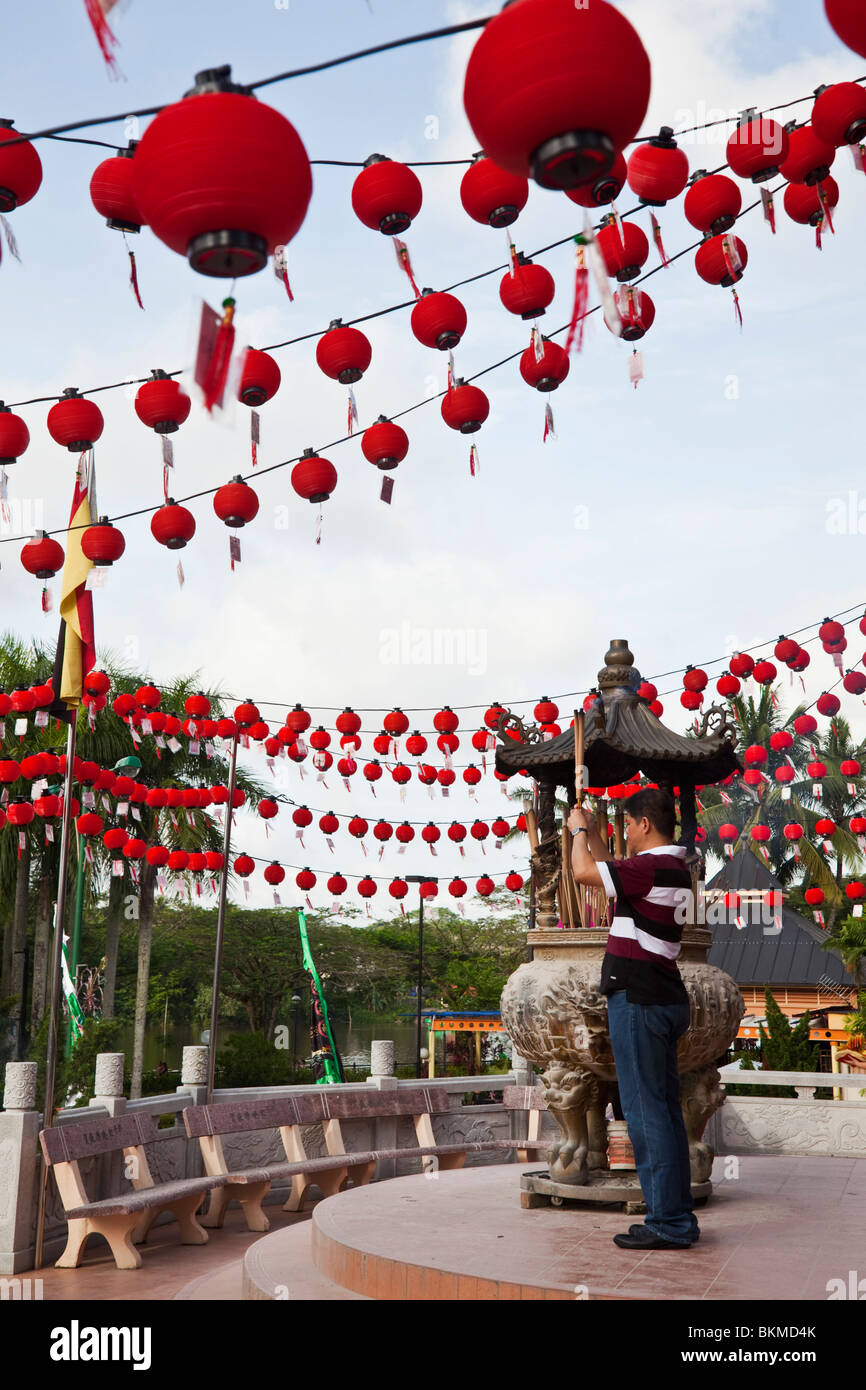 Ein Anhänger macht ein Angebot bei den Tua Pek Kong chinesischen Tempel Weihrauch. Kuching, Sarawak, Borneo, Malaysia. Stockfoto