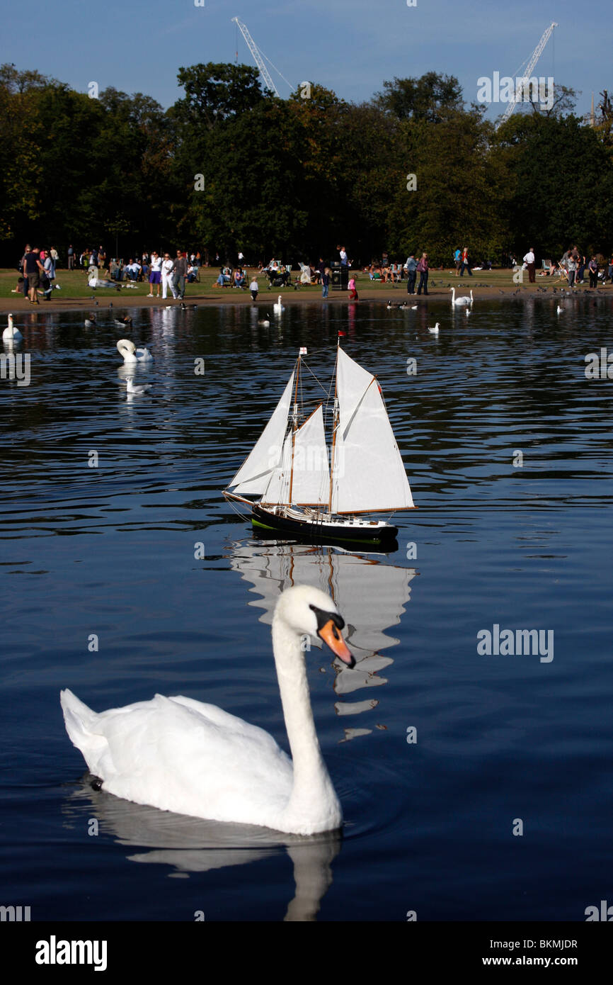 Schwäne und Modellboote auf dem runden Teich in den Kensington Gardens Stockfoto