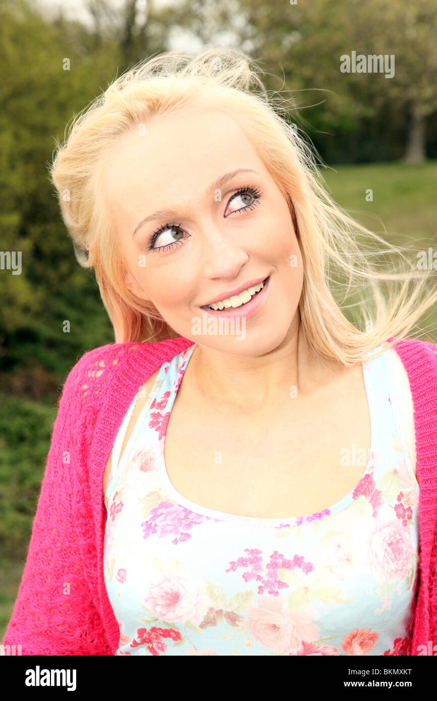 Hübsche junge blonde Frau blickte tief in in einem Park durchdacht Stockfoto