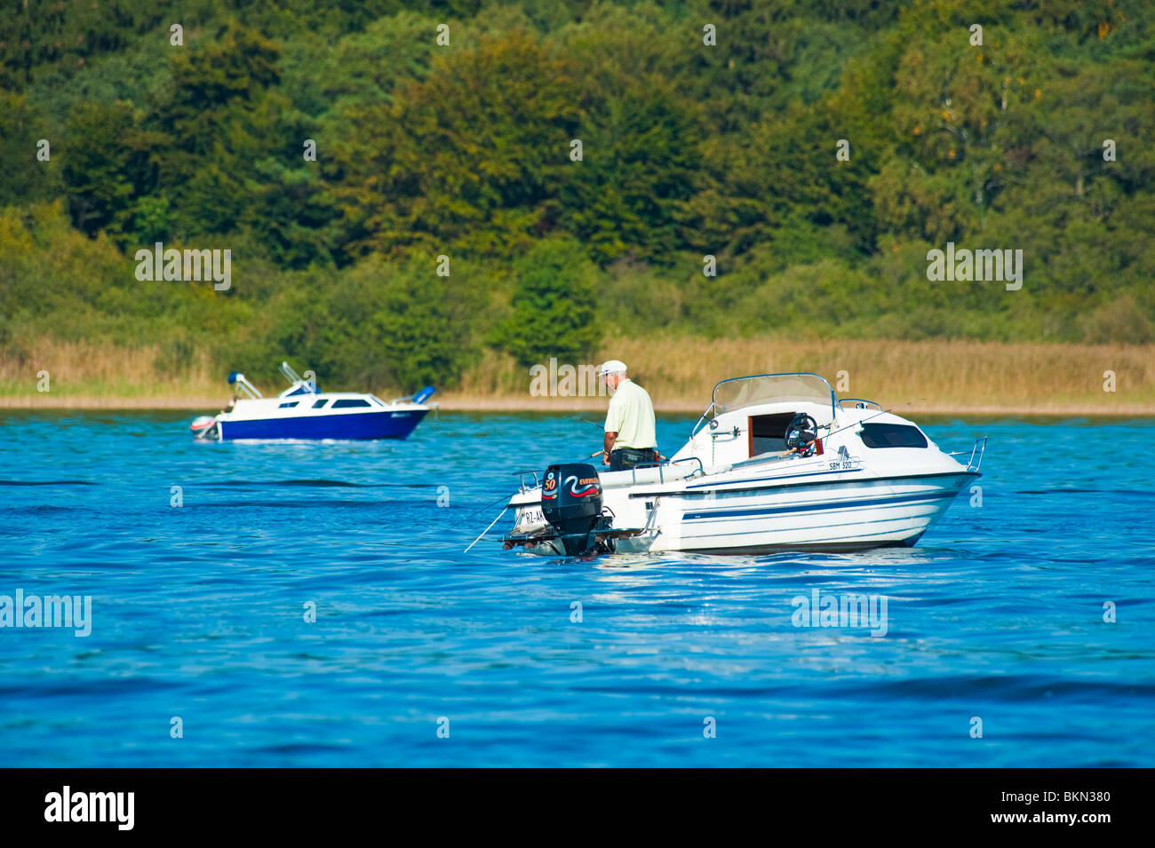 Fischer am kleinen Freizeit Boot Angeln an einem See in der Nähe von Müritz, Meckenburg-Vorpommern, Deutschland Stockfoto