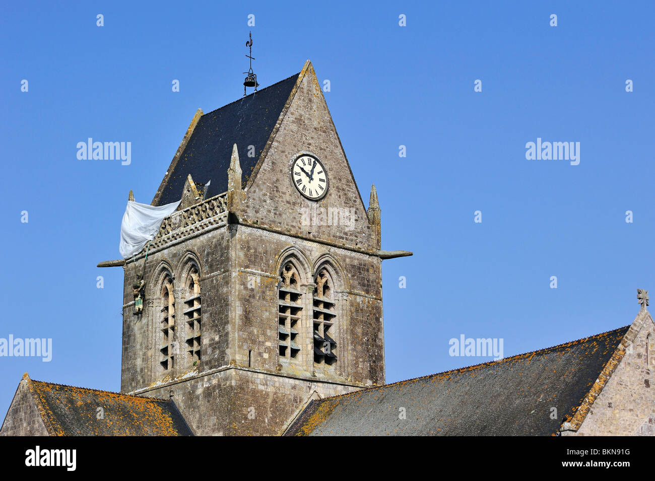 Weltkrieg zwei Fallschirm Denkmal zu Ehren des WW2 Fallschirmspringer John Steele am Kirchturm, Sainte-Mère-Église, Normandie, Frankreich Stockfoto