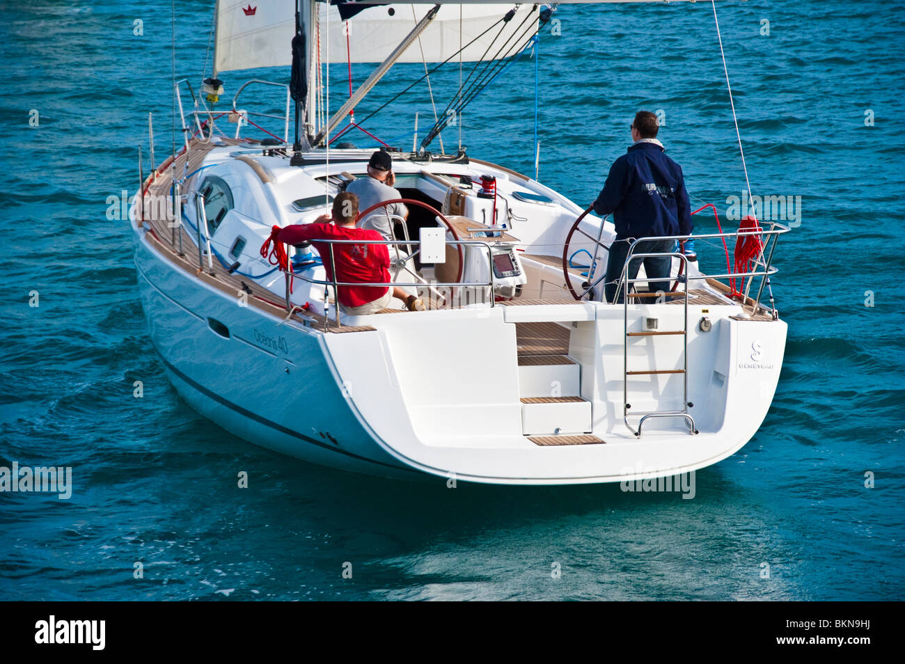 Steuermann oder Kapitän mit Crew im Cockpit von Beneteau Oceanis 40, Heck Ansicht Stockfoto