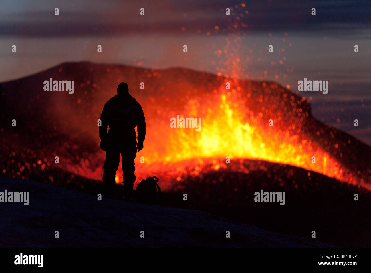 Silhouette der Tourist, der die Island 2010 Vulkanausbruch des Vulkans Eyjafjalla aus sicherer Entfernung beobachtet. Stockfoto