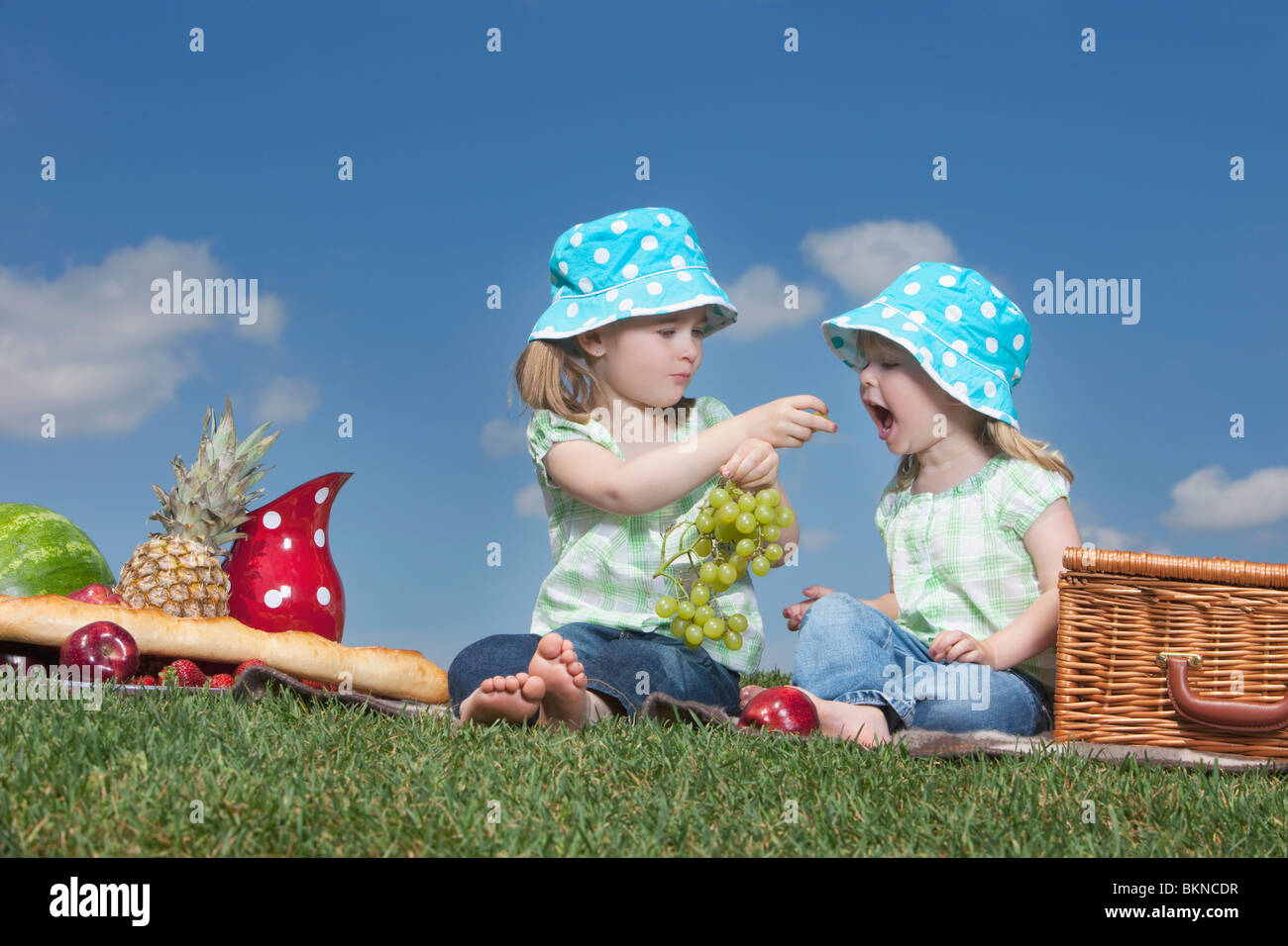 Zwei junge Mädchen teilen Trauben bei einem Picknick Stockfoto