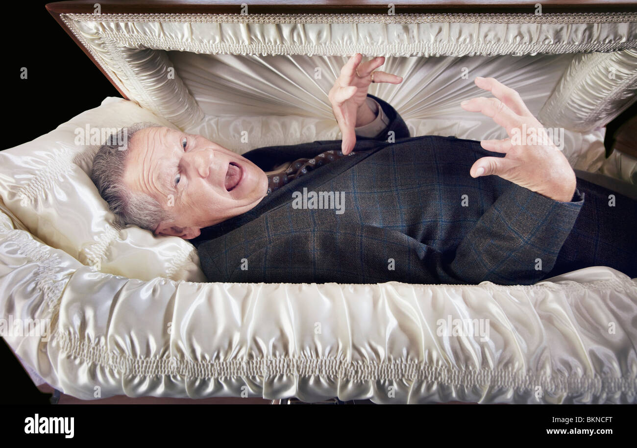A Man Alive And Laying In A Coffin Stockfoto