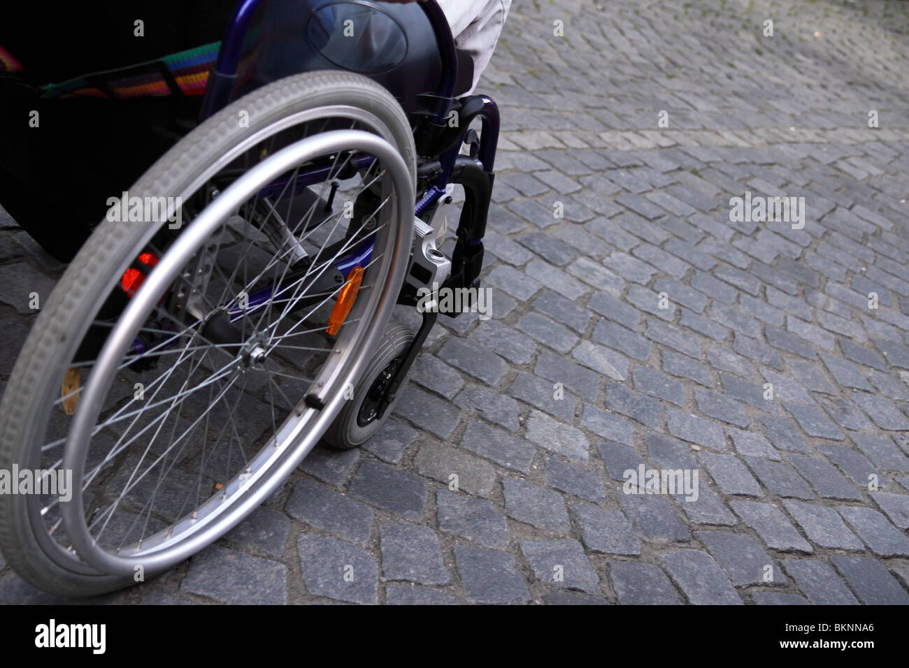 Detail-Rollstuhl auf Kopfsteinpflaster Stockfoto