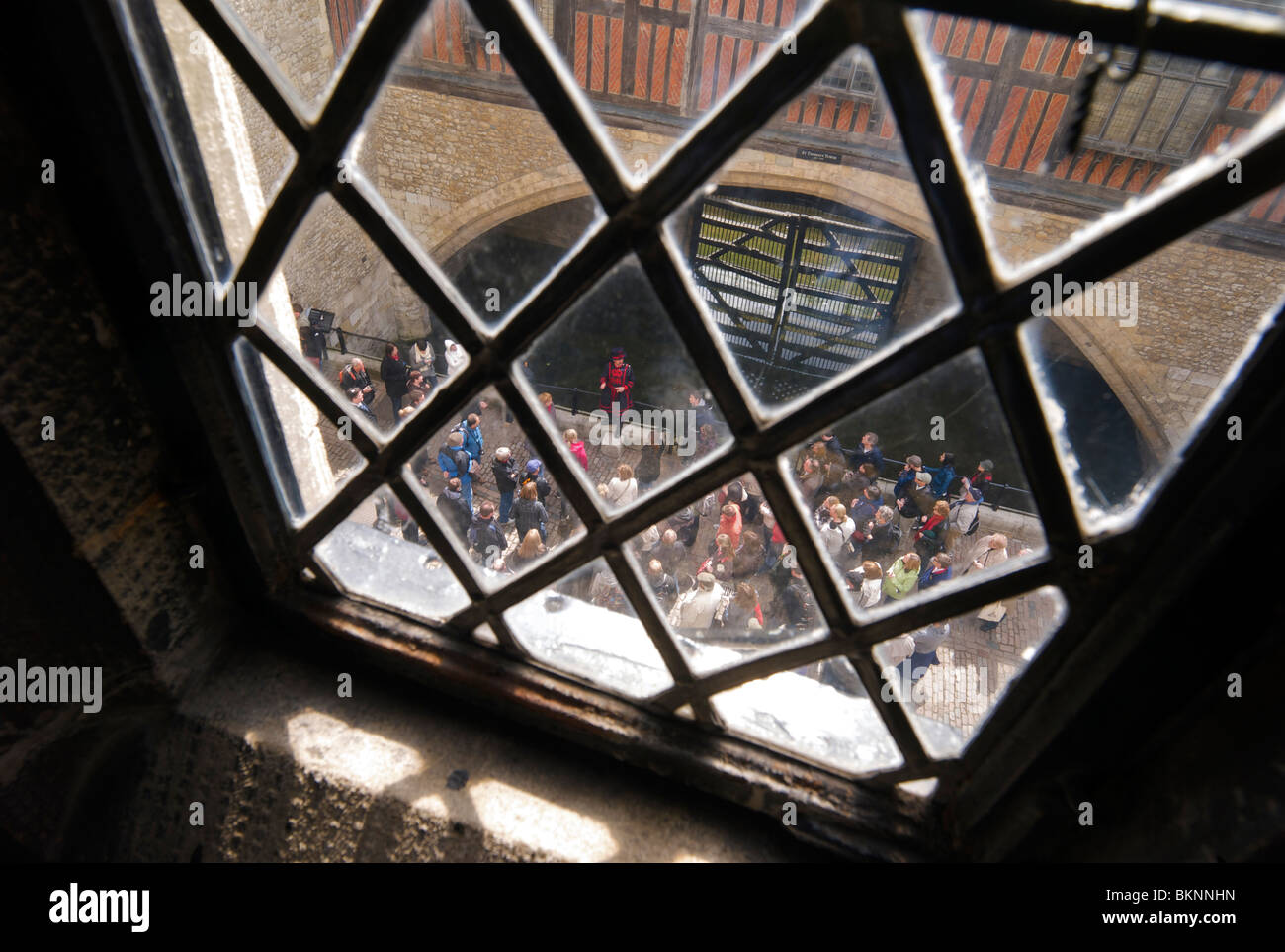 Ein Yeoman Warder oder Beefeater führt Touristen in der Nähe des Verräters Tor in den Tower of London Stockfoto