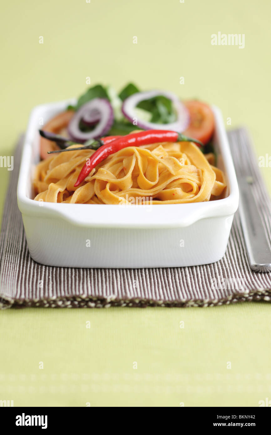 Authentische italienische Stil bunte Paprika und Chili Tagliatelle Mahlzeit mit Salat und keine Leute auf einem Tisch einstellen Stockfoto