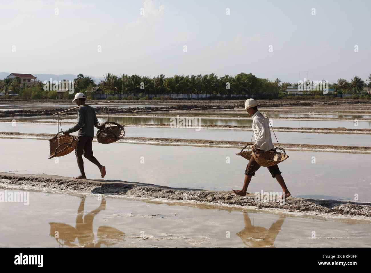 Männer und Frauen arbeiten in der glühend heißen Salz Farmen von Kampot, Kambodscha. Stockfoto