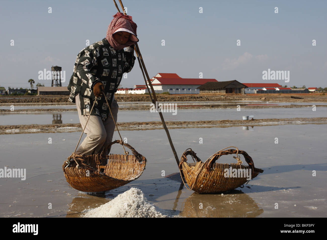 Eine Frau Bürsten Salz auf einem Salz Bauernhof in der Nähe von Kampot, Kambodscha Stockfoto