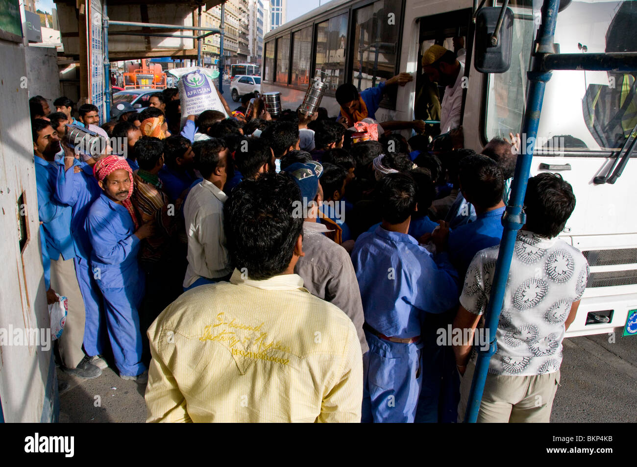 Ausländische Arbeitnehmer mit Bus Dubai Stockfoto