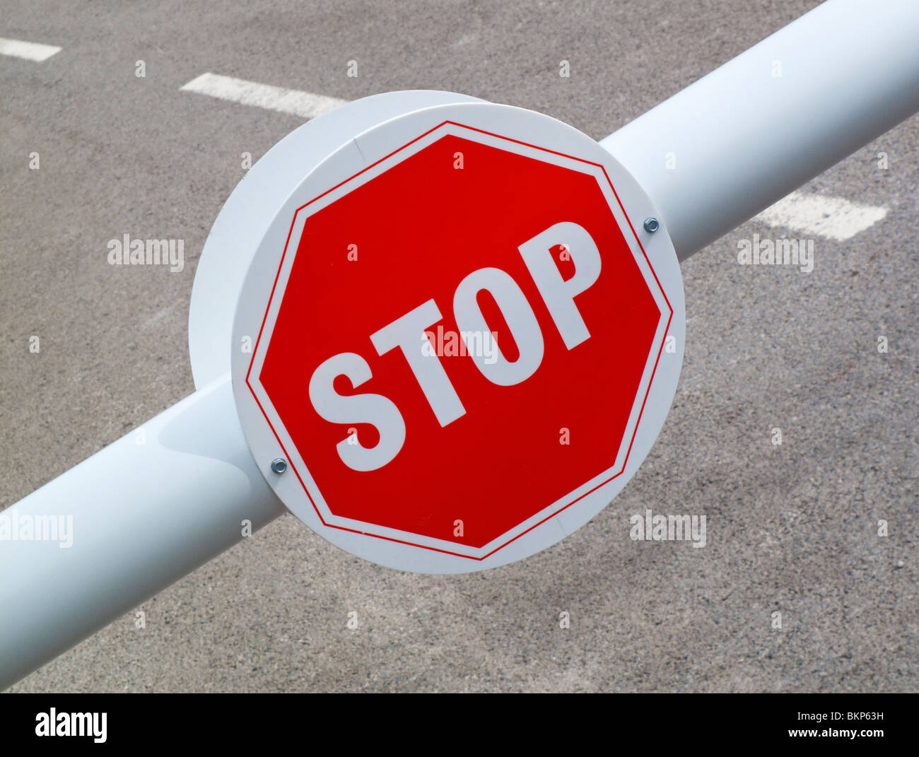 Roten Stop Schild an Barriere mit Straße hinter Stockfoto