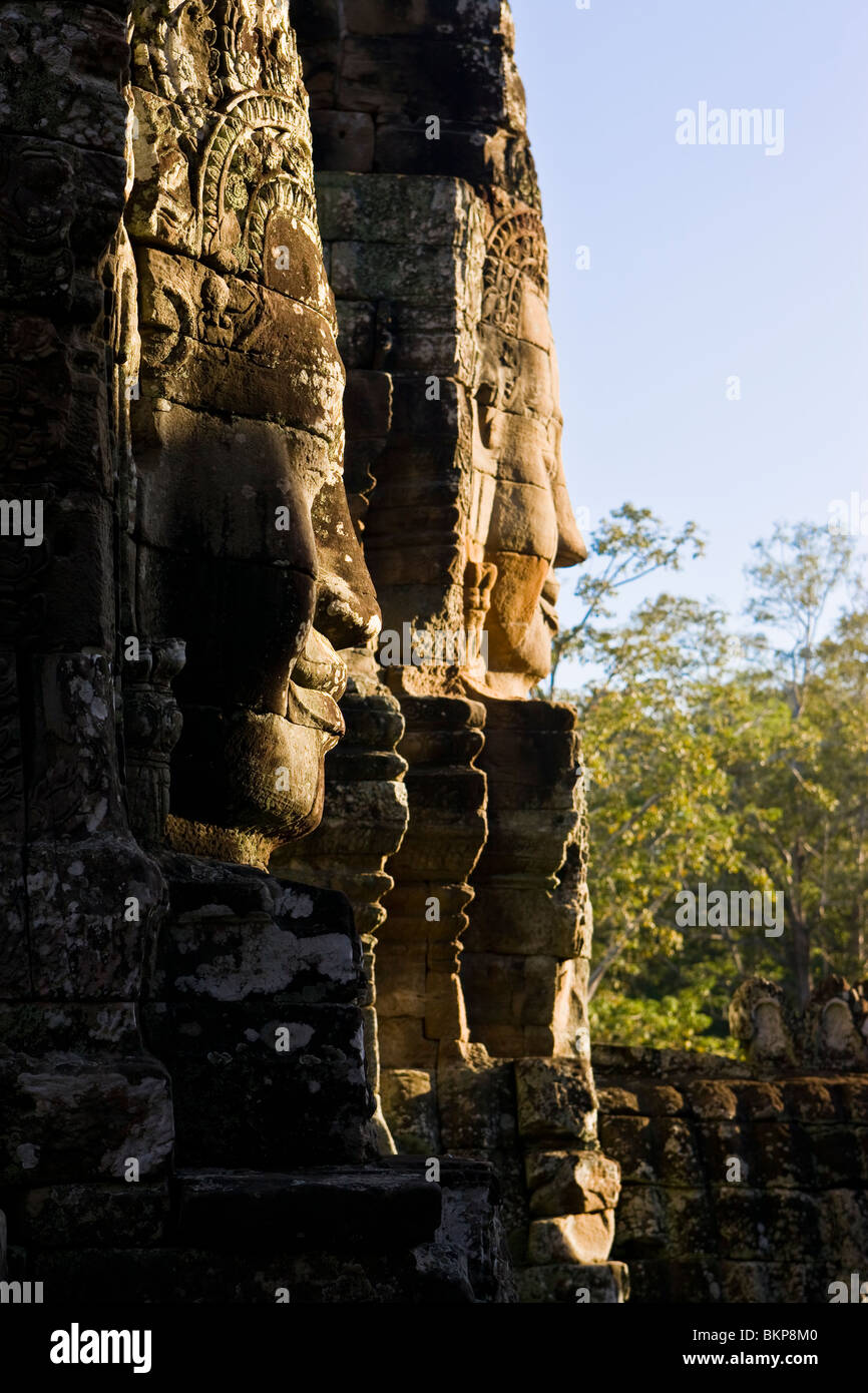 Geschnitzte Gesichter bei den Bayon bei Sonnenuntergang. Stockfoto