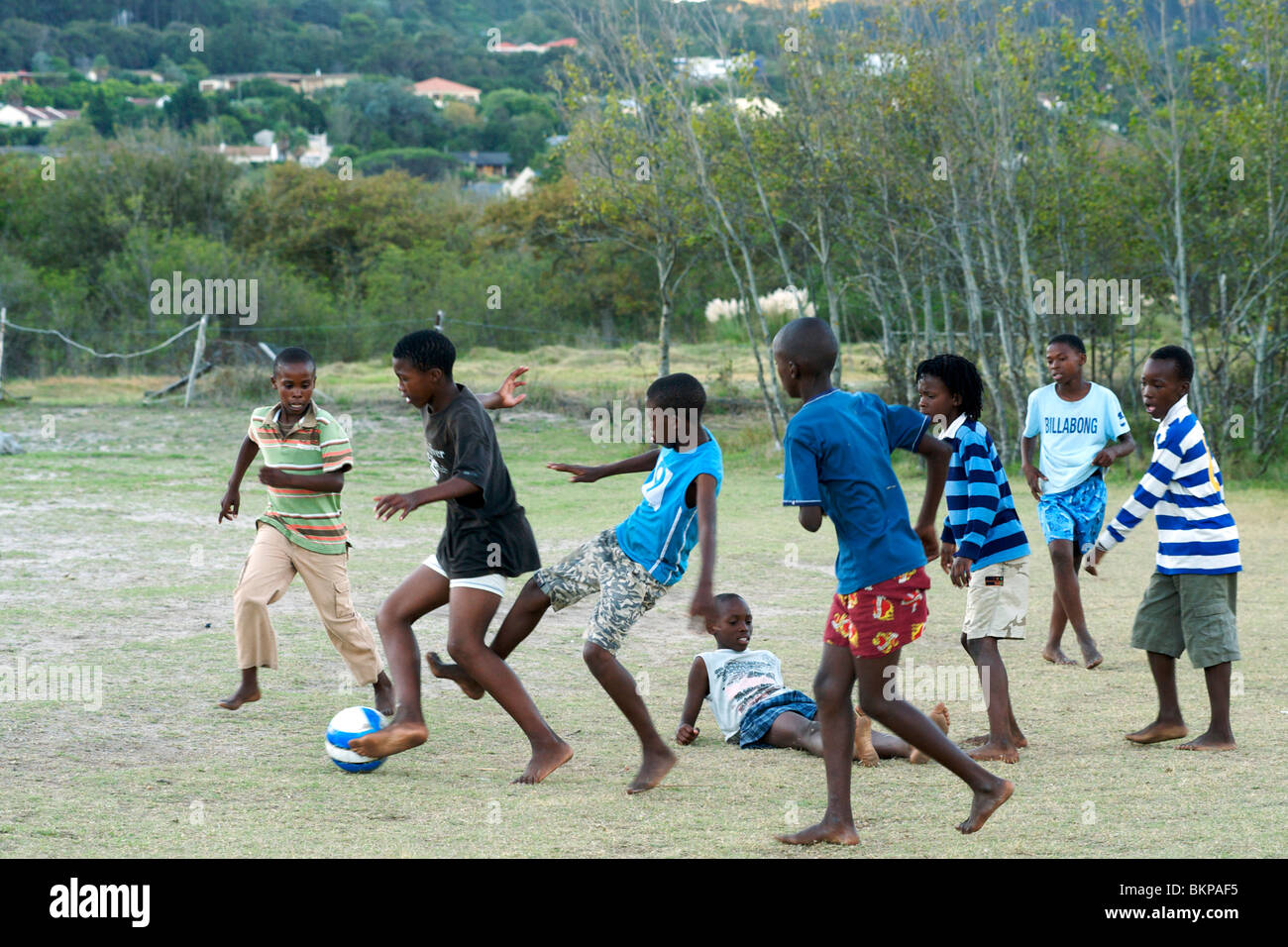 Afrikanische Kinder Fußballspielen barfuß in einem Feld in Hout Bay in