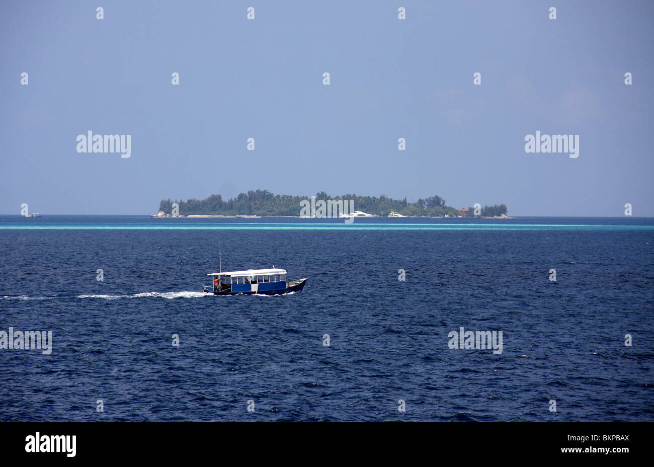 Touristenboot und Resort in einem sandigen Strand mit blauem Wasser, Mali, Malediven, Asien Stockfoto