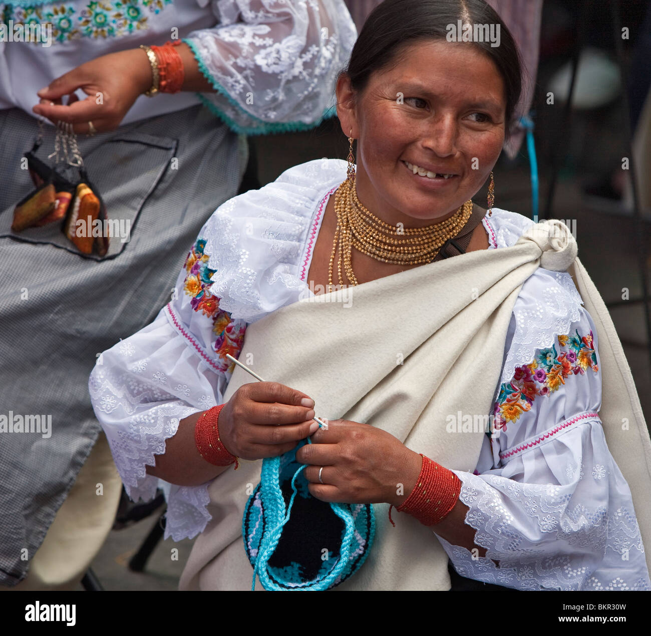 Ecuador, eine indigene ecuadorianischen Frau damit beschäftigt, eine wollene Mütze in Otavalo Markt. Stockfoto