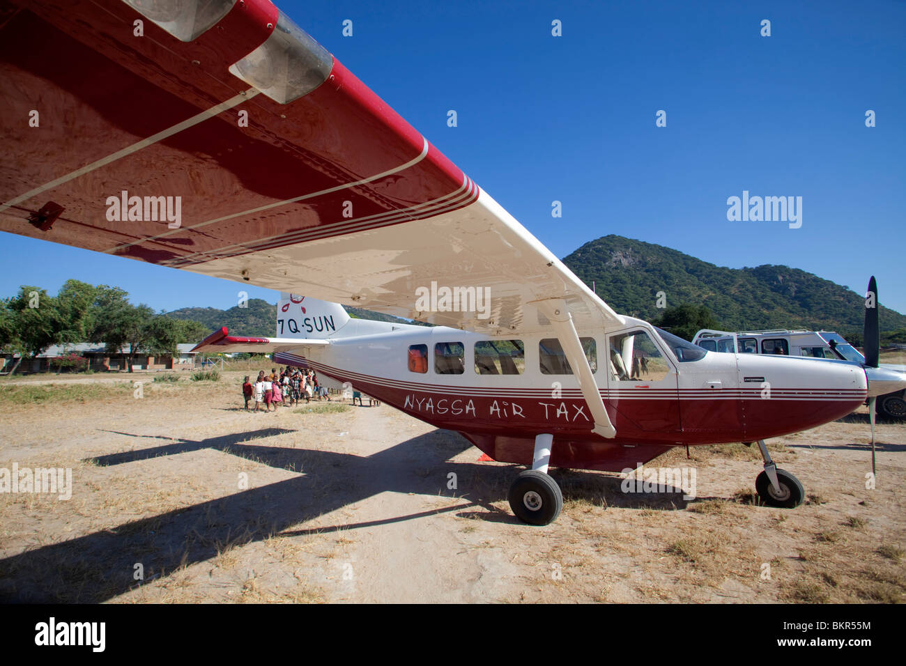 Malawi, Nyassa Air Taxi livrierter Flugzeug wartet auf Bush Landepiste für Passagiere Stockfoto