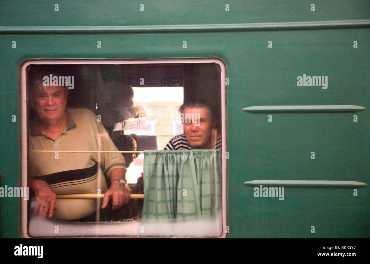 Russland, Sibirien; Trans-Siberian; Zwei ältere Männer suchen gegenüber einem fahrenden Zug, Irkutsk Stockfoto