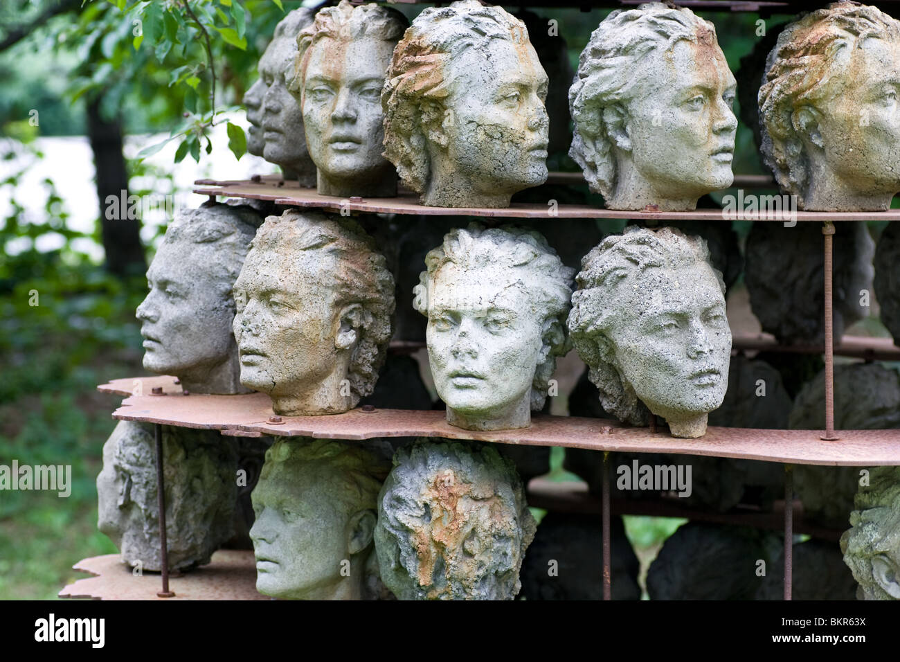 Eine Skulptur zeigt 3 Reihen von menschlichen Köpfen.  Gezeigt in einem Skulpturenpark in Guelph, Ontario, Kanada. Stockfoto