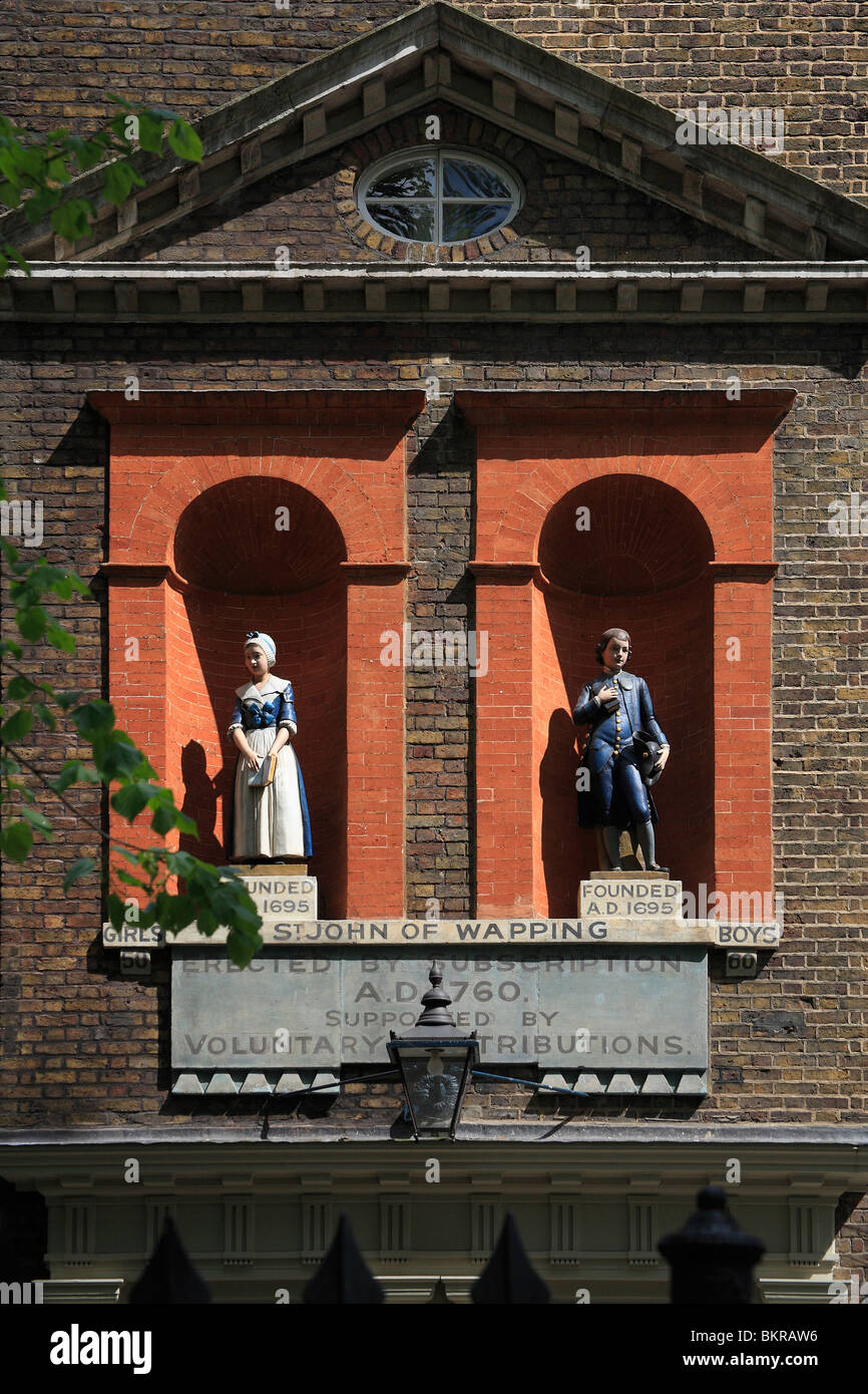 18. Jahrhundert alten Schulhaus, gegründet 1760, Statuen von einem jungen und einem Mädchen unter einem dreieckigen Giebel Inschrift Datum Stockfoto