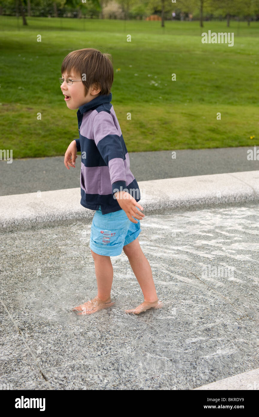 Zwei Kinder spielen in den Prinzessin-Diana-Gedenkbrunnen im Hyde Park, London. Stockfoto