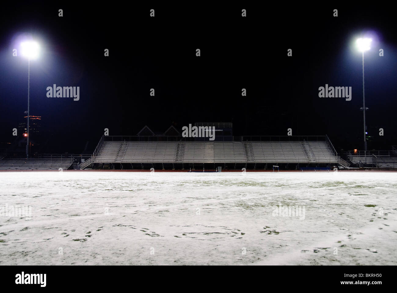 High School Fußball-Stadion in der Nacht eine leichte verschneiten mit Flutlicht Stockfoto