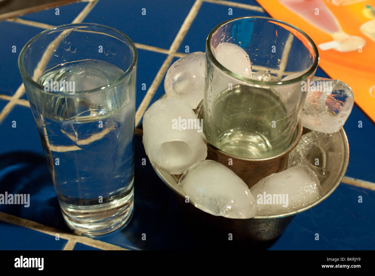 Türkische Raki, serviert in einem Glas umgeben von Eis in einem Metallhalter, mit einem Glas Wasser zu verdünnen Stockfoto