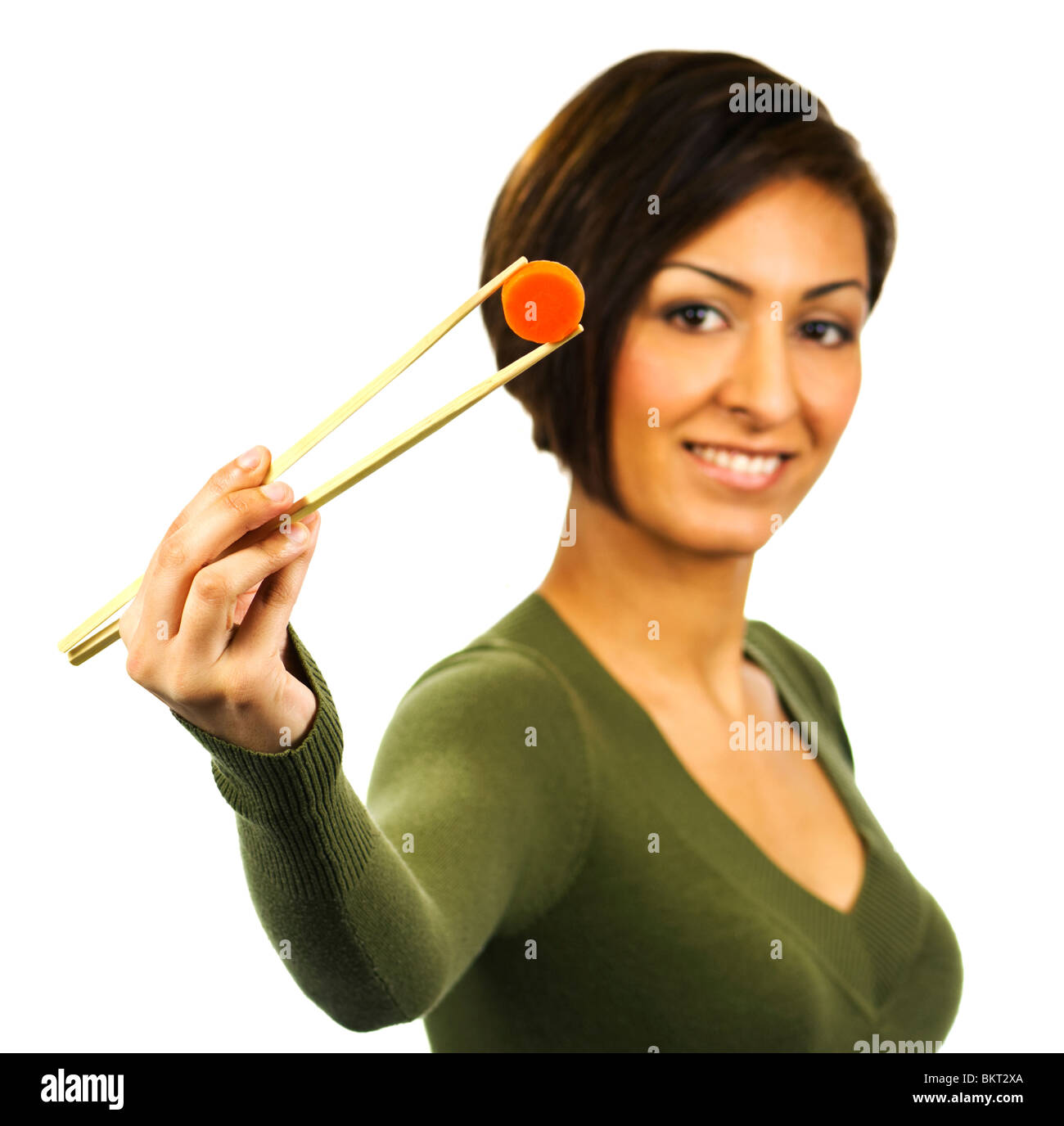 Lächelnde Frau hält ein Stück gekochte Karotten mit Stäbchen. Stockfoto