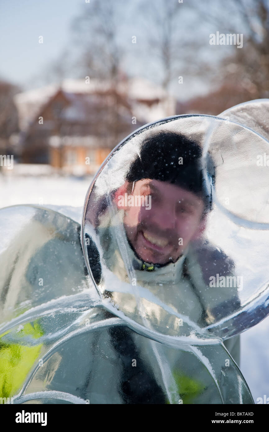 Mann auf der Suche durch Eis-statue Stockfoto