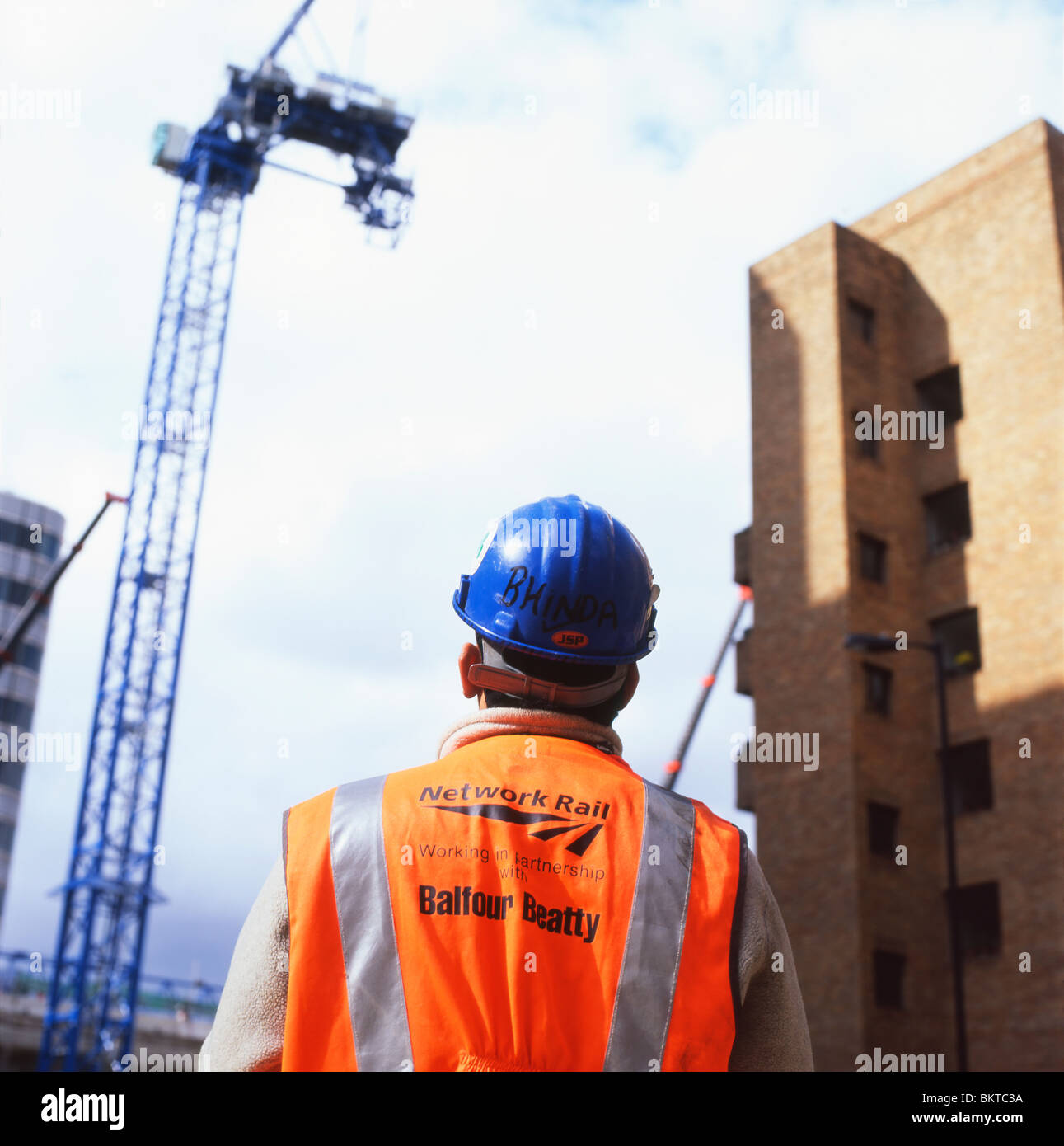 Eine Mitarbeiterin von Network Rail Balfour Beatty mit Schutzhelm, die einen Baukran bei Blackfriars South London, Großbritannien England, beobachtet, KATHY DEWITT Stockfoto