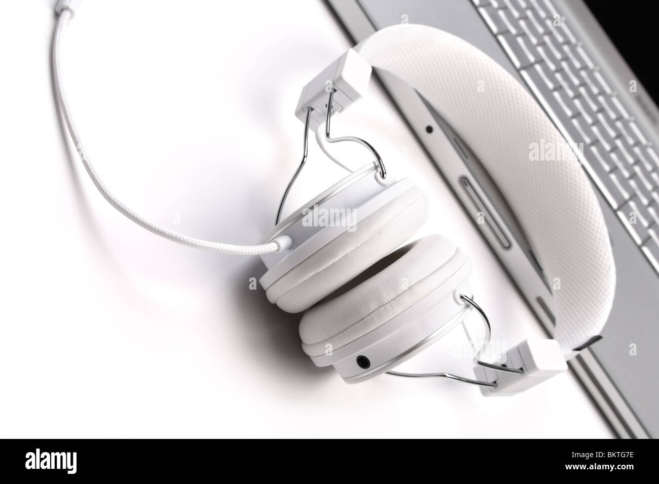Weiße Eleganz Kopfhörer und Laptop auf weißem Hintergrund neigen Ansicht. Stockfoto