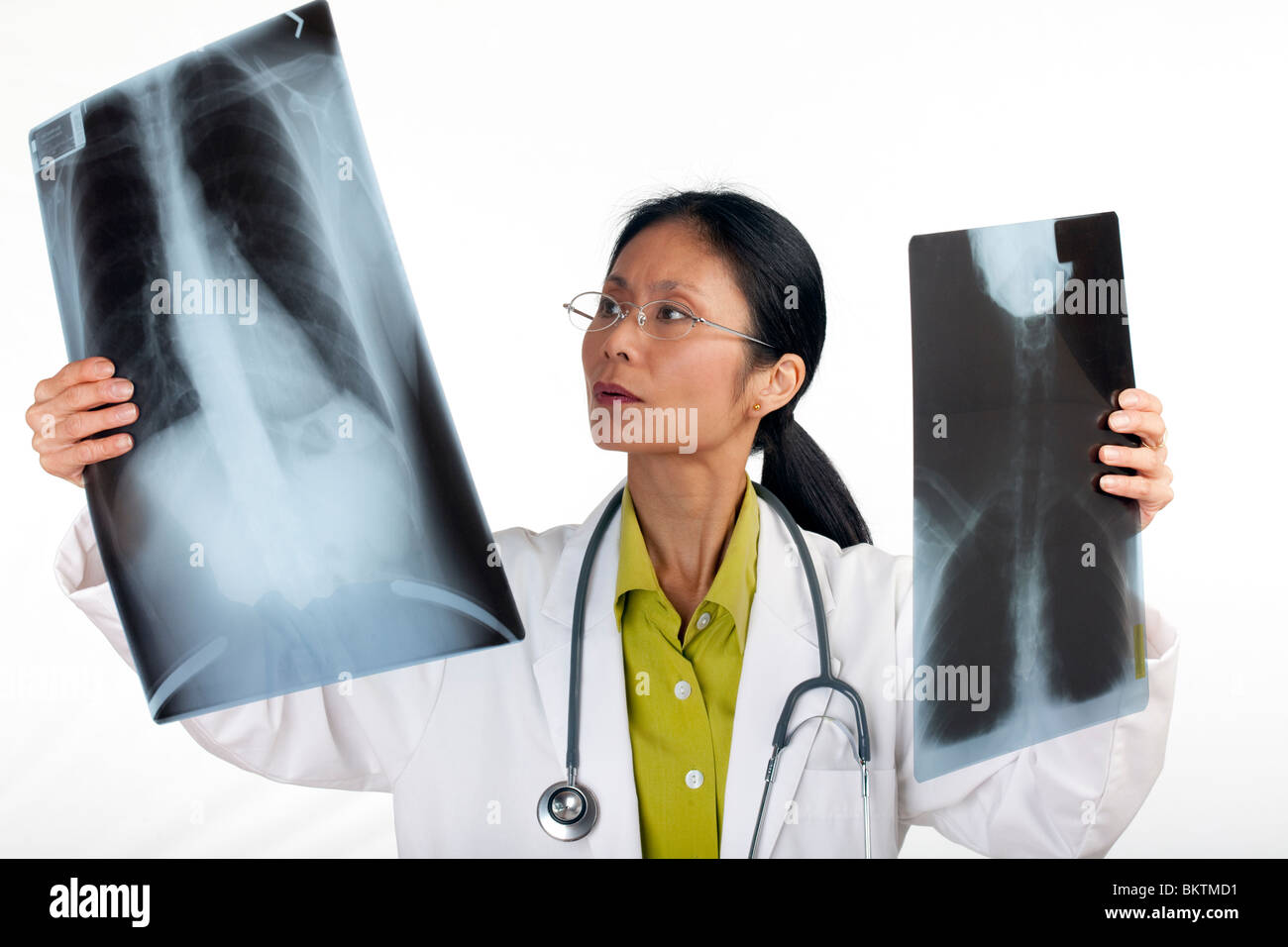 Asiatische Frauen Arzt überprüft die Ergebnisse der eine Röntgenaufnahme. Horizontalen Schuss. Isoliert auf weiss. Stockfoto